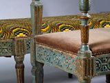 a bench with a peacock on it and a chair with a cushion on it