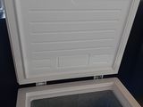 a small white freezer that is open on a table