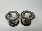two silver vases sitting next to each other on a table