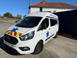 a white van parked in front of a building with an ambulance on the side of it