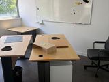une photo d'un bureau vide avec un bureau et des chaises