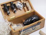 a wooden box with tools in it on a white surface