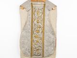 an image of a white and gold vest hanging on a wooden hanger