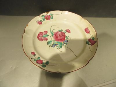 une assiette blanche ornée de fleurs roses, posée sur une table
