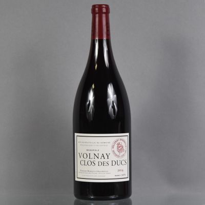 a bottle of red wine sitting on top of a glass table