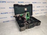 a green drill in a black case on a white surface