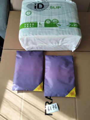 deux paquets de couches et un oreiller posés sur une boîte