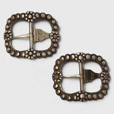 une paire de boucles anciennes en argent sur fond blanc