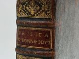 an old book sitting on top of a white surface