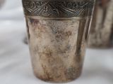 three silver cups sitting on a table next to each other