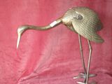 figurine de grue en laiton sur fond de velours rouge