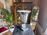 a silver vase sitting on top of a table in a living room