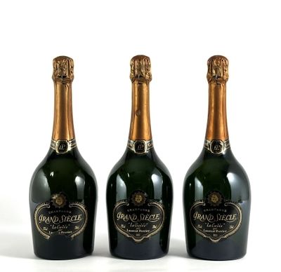 trois bouteilles de champagne posées les unes à côté des autres sur une surface blanche