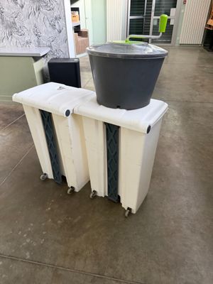 a trash can sitting on top of a radiator next to a trash can