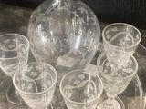bottles and glasses on a tray with a glass decanter in the background