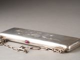 a silver purse with a chain around it on a table