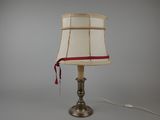 une lampe posée sur une table, ornée d'un ruban rouge