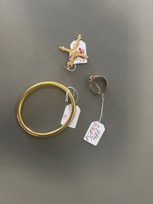 une bague en or, un porte-clés et un autre porte-clés posés sur une table