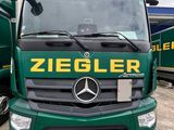 a green truck that is parked next to other trucks
