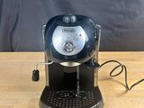 a close up of a coffee maker on a wooden table