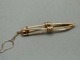 an image of a gold plated pen with a chain attached to it