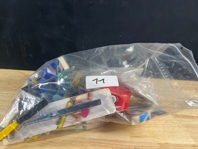 un sac en plastique rempli d'objets divers posé sur une table en bois