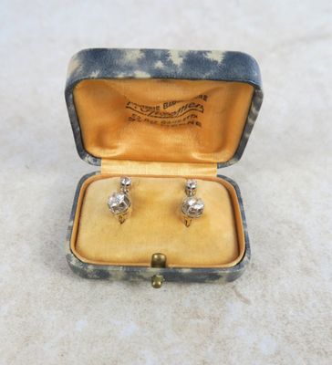 an image of a pair of diamond stud earrings in a case