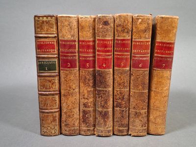 six vieux livres sont alignés sur une surface grise
