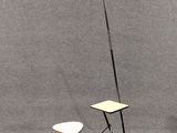 une petite table et un petit tabouret devant un fond gris