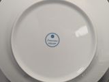 two plates and a bowl on a table with a plate holder