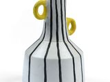 un vase rayé de blanc et de noir, avec des anses jaunes