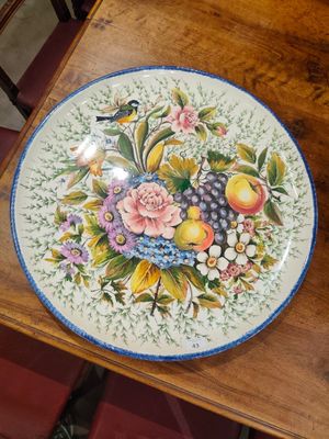 une assiette posée sur une table, sur laquelle se trouvent des fleurs et des fruits