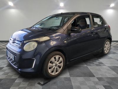 la photo d'une petite voiture bleue sur un sol en damier