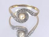 une bague avec une perle à l'intérieur, posée sur un fond blanc