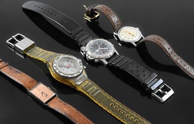 three different watches are sitting on a black surface with a black background