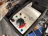 a person holding a multimeter in a black bag