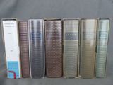 plusieurs livres sont alignés sur une surface grise