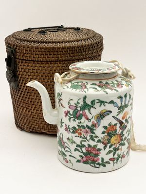 a tea pot and a basket sitting next to each other