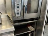 a silver oven sitting in a kitchen with a toaster oven