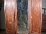 a wooden armoire with a mirror on top of it