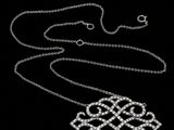 an image of a silver necklace on a black background