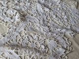 a white doily on a bed next to a pillow