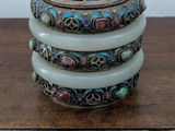 three stacked bangles with multi colored stones on a wooden table