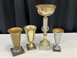 trois coupes en or et un calice en or posés sur une table