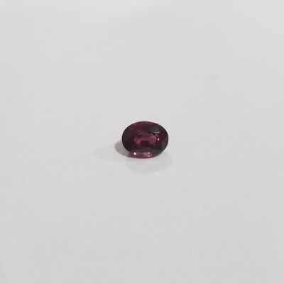 gros plan d'une pierre précieuse violette sur une surface blanche