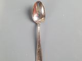 silver spoon on a white plate on a gray surface