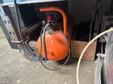 an orange air compressor sitting in the back of a truck