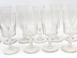 six verres à vin transparents posés les uns à côté des autres sur une surface blanche