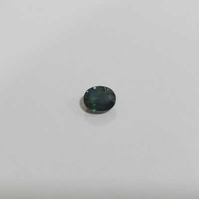a green tourmaline stone on a white surface