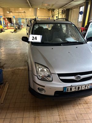 une voiture argentée garée dans un garage, avec une plaque d'immatriculation à l'avant